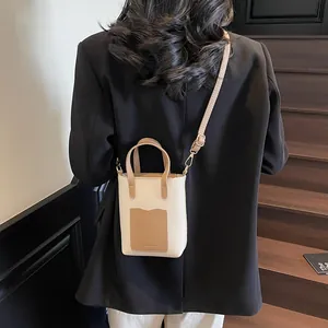 Détail du sac seau minimaliste en similicuir grainé avec inscription Fashion et sangle
