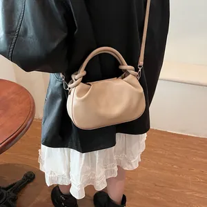 Model showing beige pleated dumpling bag with adjustable strap and metallic hardware
