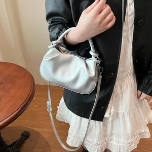 Macro shot of silver pleated cloud bag featuring Fashion & Bags logo and adjustable strap