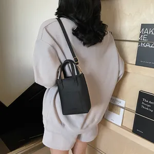 Détail du sac seau noir en cuir grainé avec logo FASHION gravé et bandoulière amovible