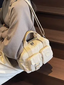 Creamy white nylon multi-pocket tote bag with adjustable shoulder strap and top handles