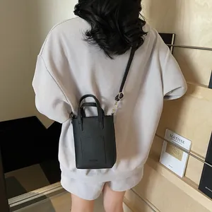 Détail du sac seau noir avec texture litchi et gaufrage Fashion porté par le mannequin