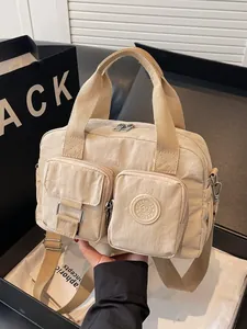 Minimalist beige nylon multi-pocket handbag with fashion logo and adjustable crossbody strap