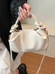 Chic beige pleated crossbody bag with large knot handles and detachable shoulder strap