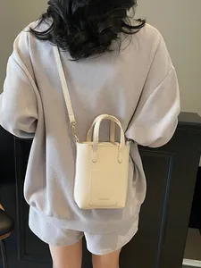 Sac seau minimaliste en cuir grainé crème avec poignée et bandoulière amovible
