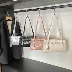 Λεπτομέρεια από τέσσερις λουστρίνι τσάντες ώμου με αγκράφα και μενταγιόν καρδιά