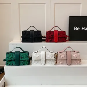 Detail of five embroidered lace handbags with butterfly appliques in various colors