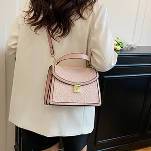 Dettaglio borsa rosa chiaro in finta pelle martellata con elegante motivo a foglie goffrato