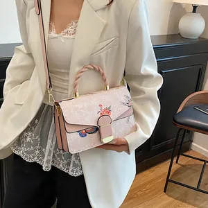 Detail der rosa Umhängetasche mit Schmetterlings- und Rosenprint an einem Modell