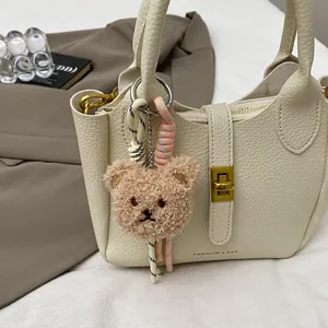 Détail d'un pendentif ours en peluche créatif avec cordes tressées sur un sac en cuir