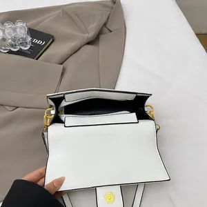 Detailed interior view of white square bag with compartments and magnetic gold closure