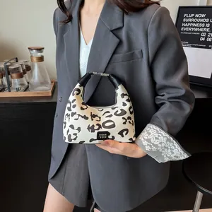 Close-up of hobo handbag with black and white leopard pattern and leather handle
