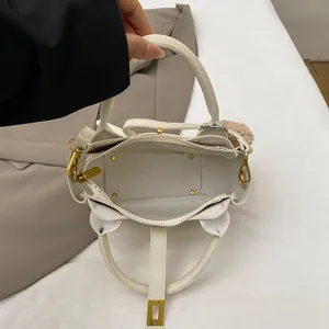 Vue de dessus du sac seau blanc montrant l'intérieur spacieux, fermeture éclair et pompon