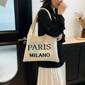 Detail van de grote gebreide shopper met Paris Milano tekst en zachte textuur