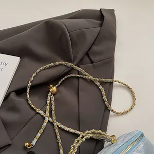 Détail du sac en cuir matelassé bleu clair avec chaîne dorée et boule ajustable