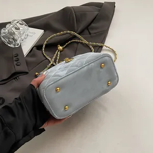 Vue détaillée du sac matelassé bleu clair avec clous dorés et boucle en métal saturne