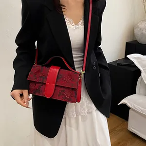 Detail of red square handbag with 3D butterfly embroidery and detachable strap