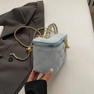 Détail du vanity bleu clair matelassé avec chaîne à boule dorée et poignée en cuir