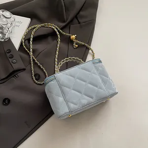 Vue détaillée du mini sac matelassé bleu clair avec finitions dorées et pieds en métal