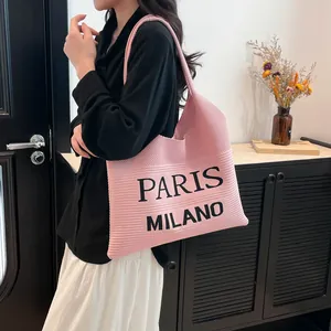 Detail van een roze gebreide shopper met zwarte Paris en Milano teksten in moderne scène
