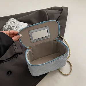 Vue détaillée d'un sac matelassé bleu montrant le rangement interne et le miroir intégré