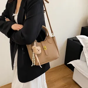 Détail du sac seau à motif litchi avec imprimé mode et accessoire porte-clés ours mignon