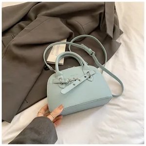 Détail du sac à main bleu clair avec texture de cuir litchi et crochet en métal