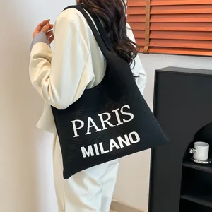 Detail van de zwarte gebreide shopper met witte Paris Milano tekst bedrukking