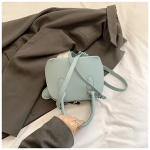 Vue à plat d'un sac à main bleu clair en cuir litchi avec des détails argentés