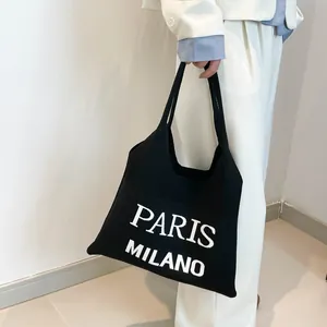 Detail van zwarte gebreide draagtas met wit PARIS MILANO letterontwerp voor dames