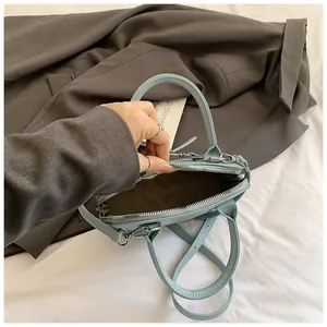 Détail intérieur du sac à main en cuir bleu clair avec fermeture éclair et doublure foncée
