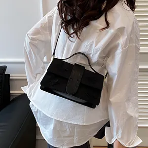 Detail of black vintage shoulder bag with embossed butterfly and wide belt buckle accent