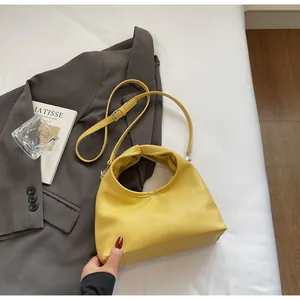 Detailed view of yellow lychee grain handbag with unique knot handle and strap