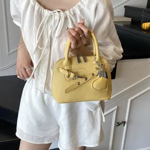Détail d'un sac jaune texture grainée avec finitions métalliques argentées chic