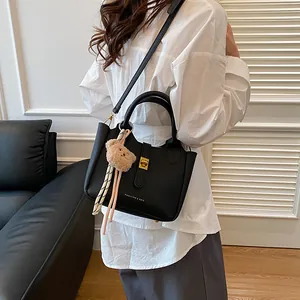 Détail du sac seau noir grainé avec fermoir doré et pendentif ours en peluche doux