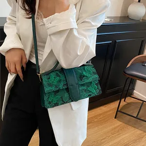 Model wearing green square bag with butterfly embroidery and elegant lace details