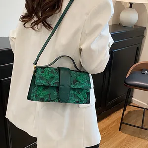 Detailed close-up of dark green jacquard bag featuring 3D embroidered butterflies and hardware