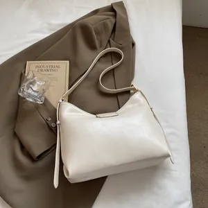 Close-up of cream white bucket bag with crackle leather texture and golden metal buckle