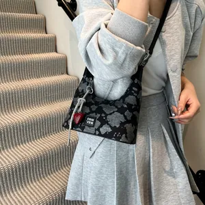 Close-up of leopard print shoulder bag with a red heart charm on minimalist stairs