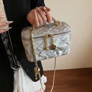 Détail du sac boîte en velours argenté avec chaîne dorée et pendentif rose
