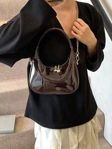 Glossy burgundy crescent-shaped leather hobo bag with gold chain and round metal charm