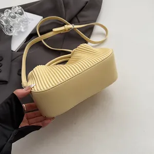 Détail d'un sac à main en cuir PU plissé jaune clair avec bandoulière réglable