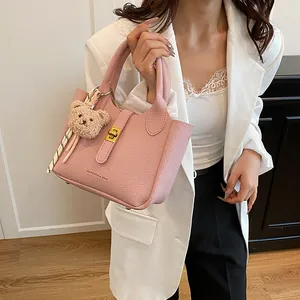 Sac seau rose texture litchi avec pendentif ours en peluche et fermoir métallique