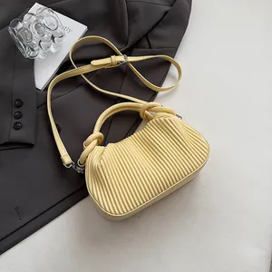 Détail du sac à main jaune clair plissé avec poignée ronde et bandoulière amovible