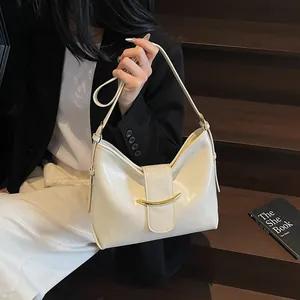 Close-up of cream PU leather hobo bag with elegant gold crescent metal clasp and smooth finish