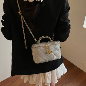 Détail de la trousse de toilette argentée matelassée avec chaîne et pendentif rose