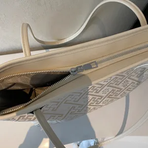 Dettaglio della cerniera in metallo e tessuto jacquard marrone su borsa tote grande