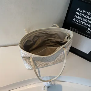 Vista dall'alto della borsa tote crema che mostra l'interno ampio e la tasca con zip