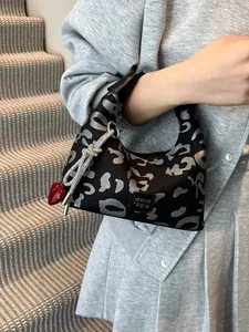 Leopard print crossbody dumpling bag with red heart charm and silver rhinestone tassel