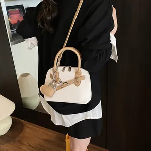 Détail du sac Boston montrant le cuir grainé blanc et la bandoulière kaki contrastée